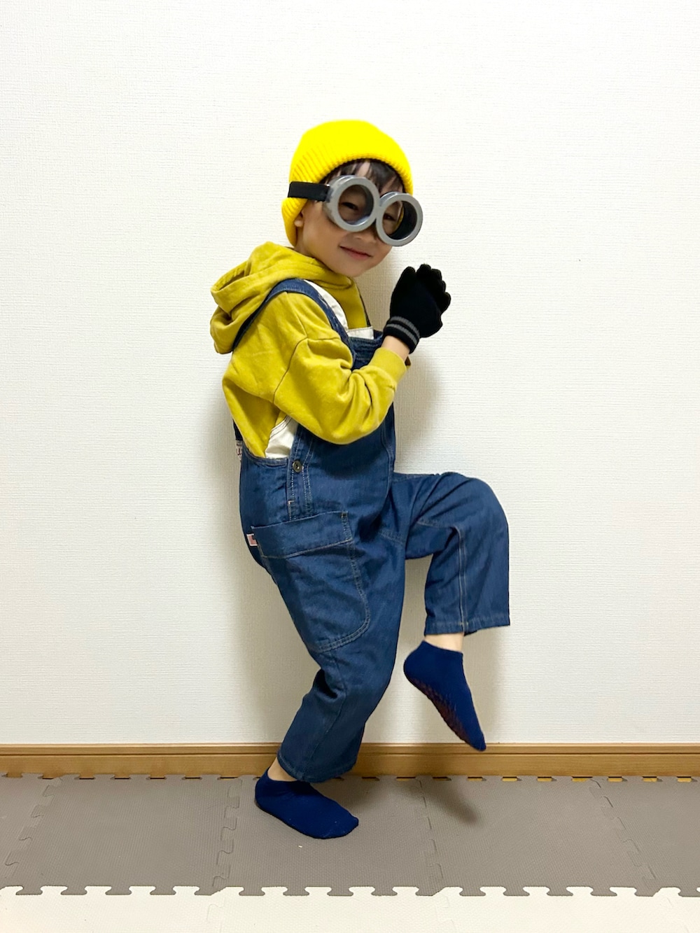 イエロー系のパーカー、ブルー系のサロペット/オーバーオール、グレー系のメガネを着用したキッズの秋コーディネートの5枚目の写真