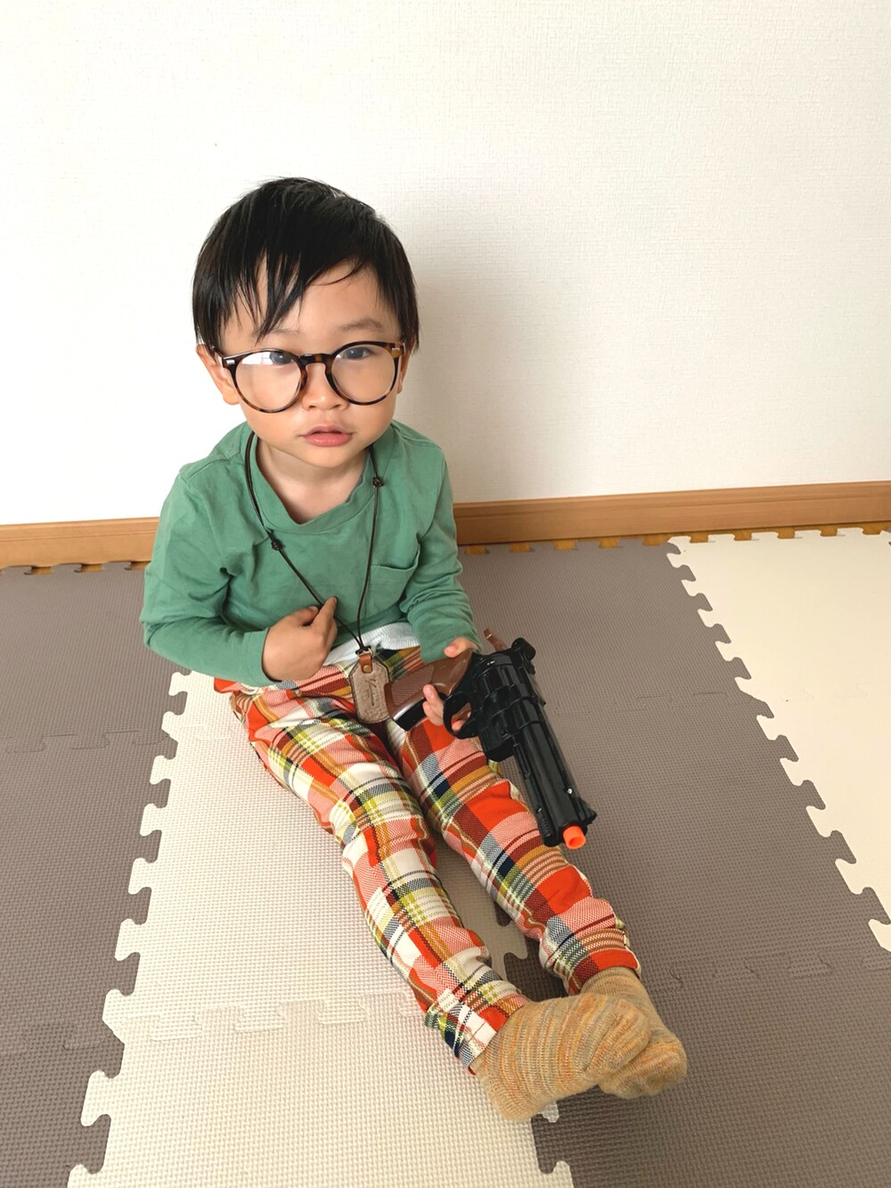 グリーン系のTシャツ/カットソー、オレンジ系のその他パンツ、ブラウン系のメガネを着用したキッズの秋コーディネートの2枚目の写真