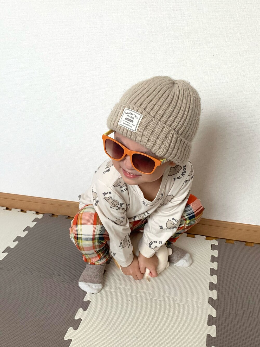 ホワイト系のスウェット、オレンジ系のその他パンツ、ベージュ系のニットキャップ/ビーニーを着用したキッズの秋コーディネートの2枚目の写真
