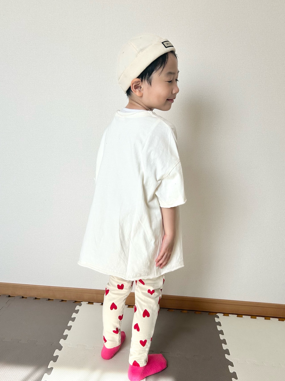 レッド系のその他パンツ、ホワイト系のTシャツ/カットソー、ホワイト系のキャップを着用したキッズの春コーディネートの3枚目の写真