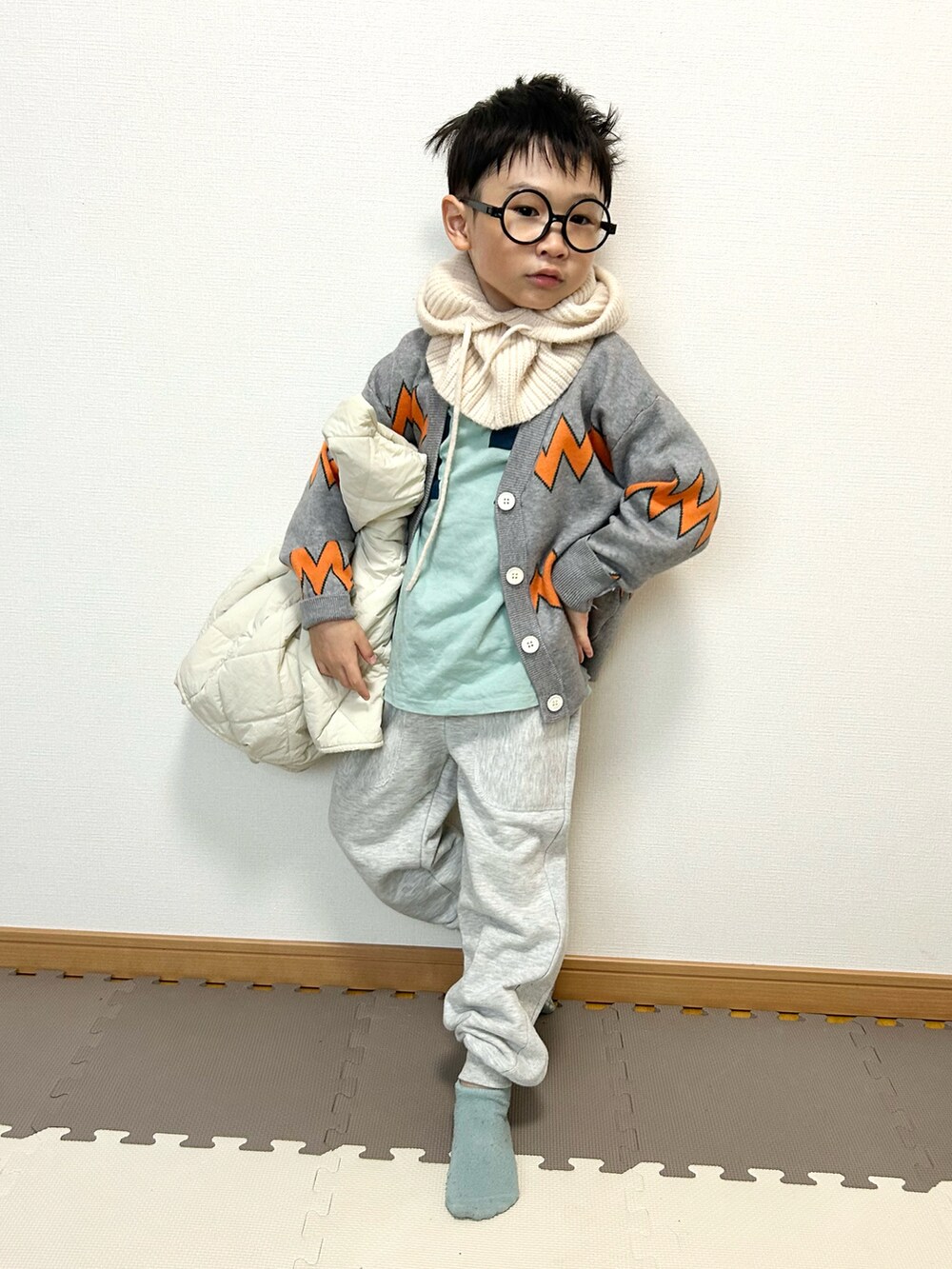 グレー系のカーディガン/ボレロ、ブルー系のTシャツ/カットソー、グレー系のスウェットパンツを着用したキッズの冬コーディネートの2枚目の写真