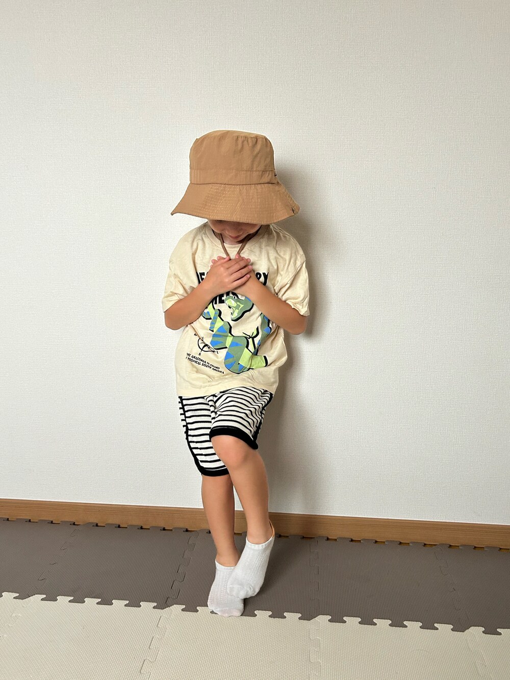 ホワイト系のセットアップ、ベージュ系のTシャツ/カットソー、オレンジ系のソックス/靴下を着用したキッズの夏コーディネートの4枚目の写真