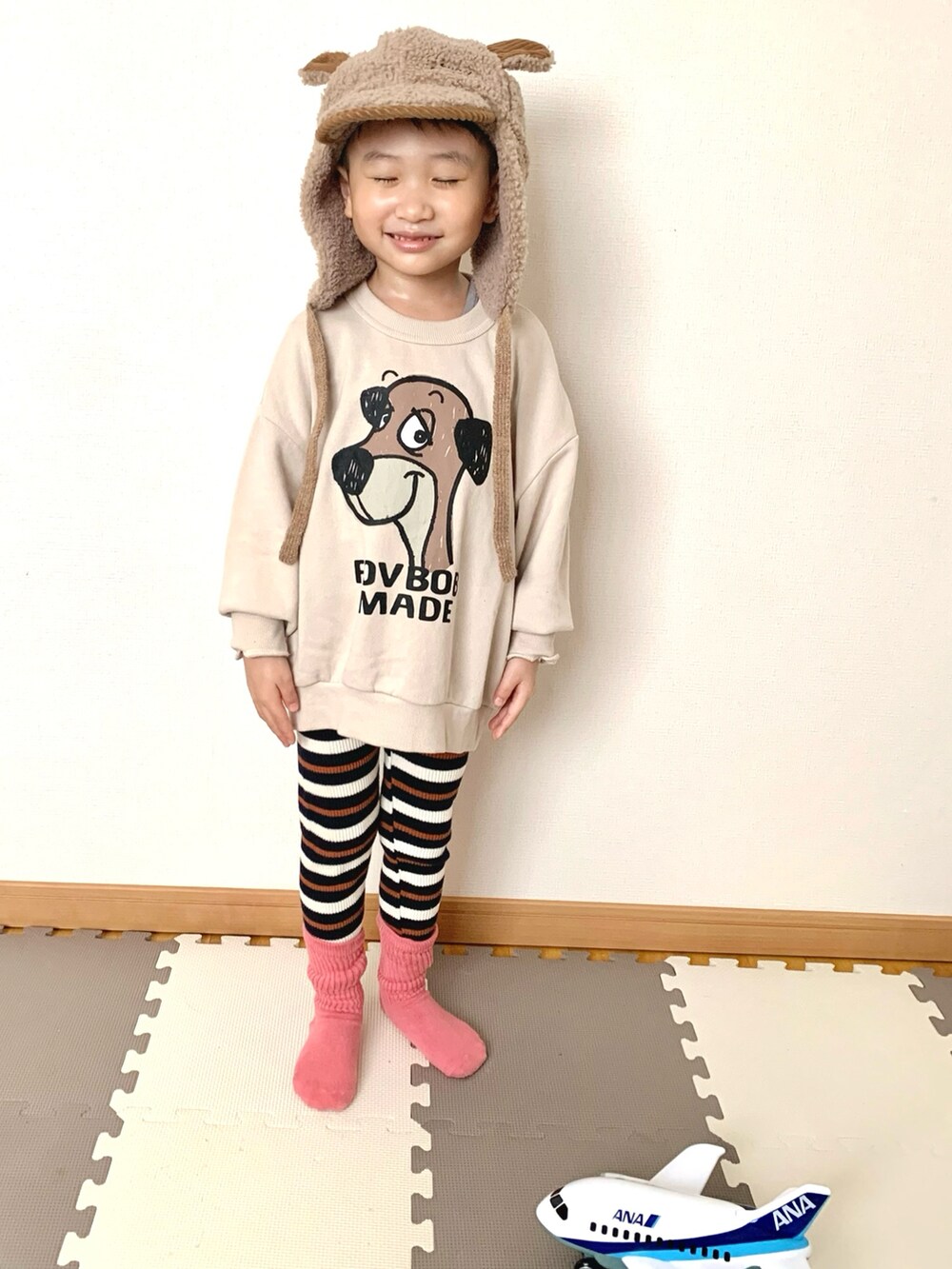 ホワイト系のスウェット、ブルー系のその他パンツ、ブラウン系の帽子を着用したキッズの冬コーディネートの5枚目の写真