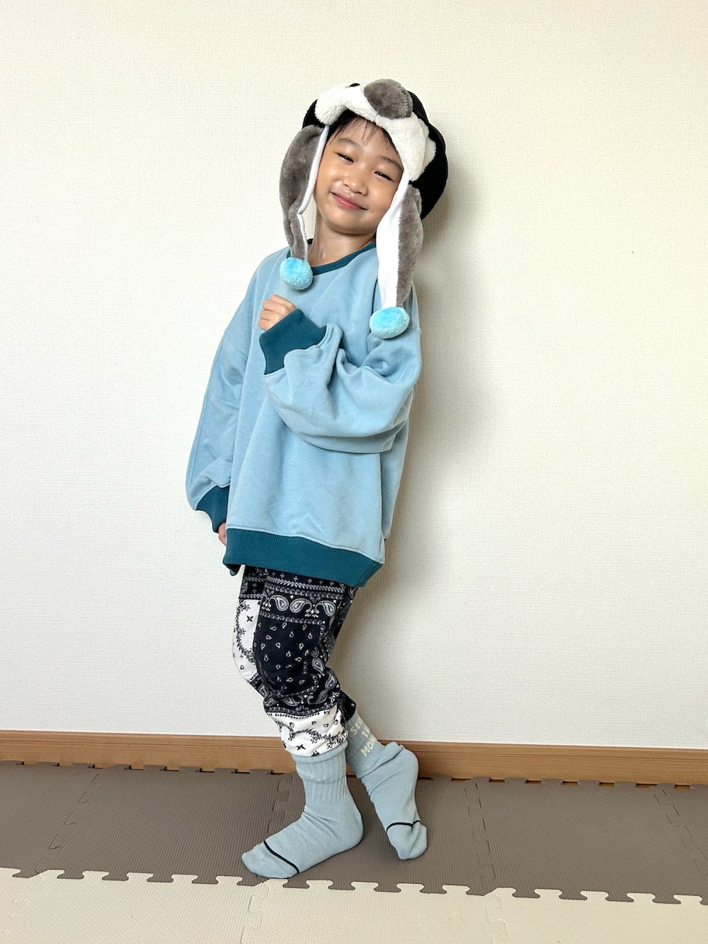 ブルー系のスウェット、ブルー系のスウェットパンツ、ブラック系の帽子を着用したキッズの秋コーディネートの2枚目の写真