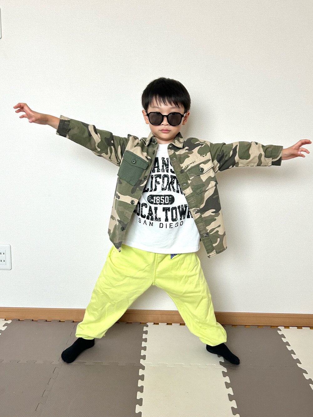 グリーン系のその他パンツ、グリーン系のミリタリージャケット、ホワイト系のTシャツ/カットソーを着用したキッズの秋コーディネートの3枚目の写真