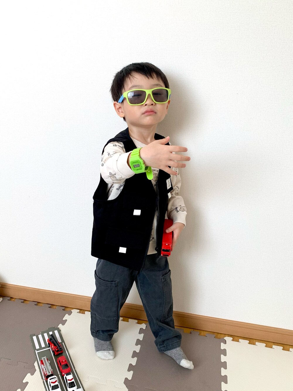 グレー系のカーゴパンツ、ブラック系のベスト、ホワイト系のスウェットを着用したキッズの春コーディネートの2枚目の写真