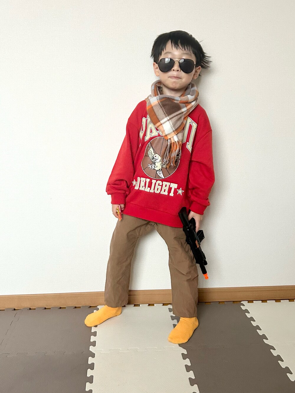 レッド系のスウェット、ブラウン系のパンツ、シルバー系のマフラーを着用したキッズの秋コーディネートの3枚目の写真