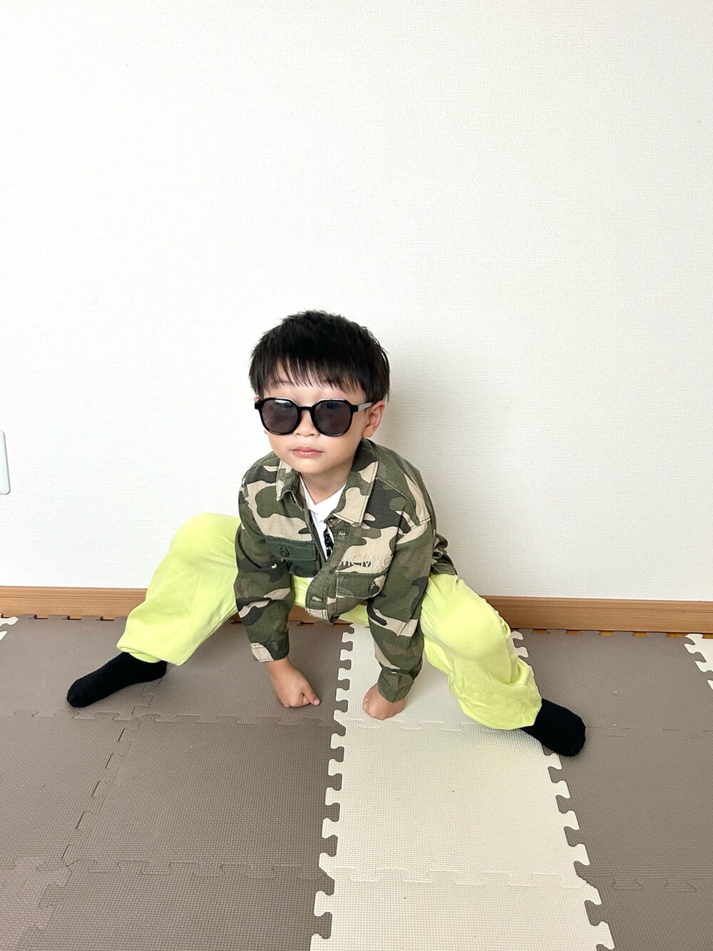 グリーン系のその他パンツ、グリーン系のミリタリージャケット、ホワイト系のTシャツ/カットソーを着用したキッズの秋コーディネートの2枚目の写真