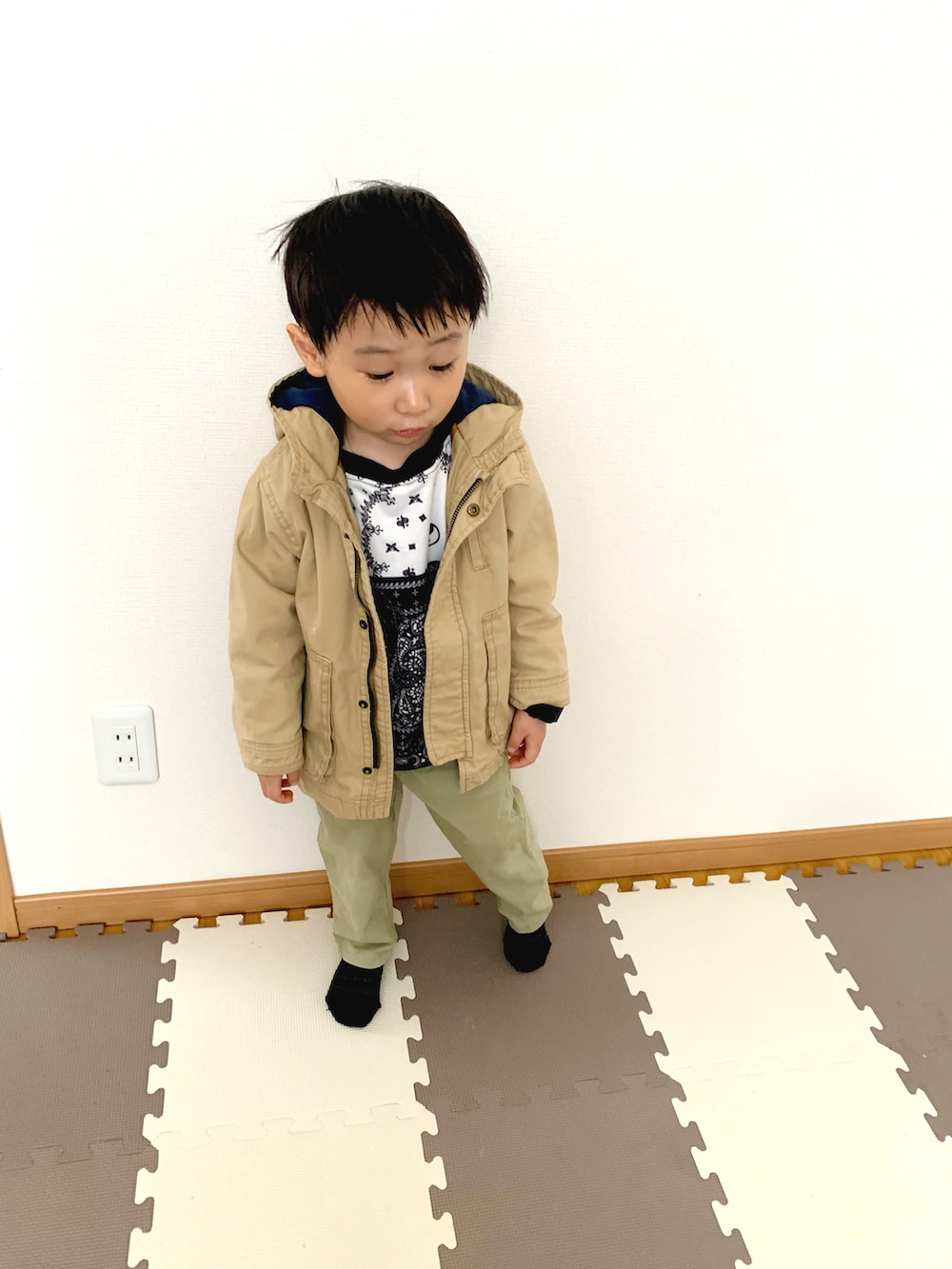 ブルー系のスウェット、ベージュ系のミリタリージャケット、グリーン系のチノパンツを着用したキッズの冬コーディネートの2枚目の写真