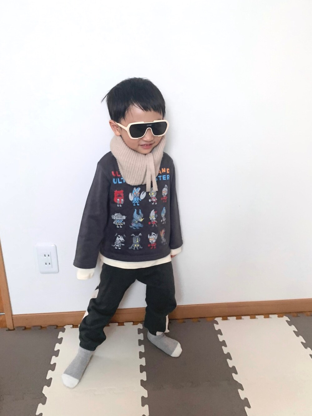 グレー系のスウェット、グレー系のスウェットパンツ、ベージュ系のTシャツ/カットソーを着用したキッズの冬コーディネートの2枚目の写真
