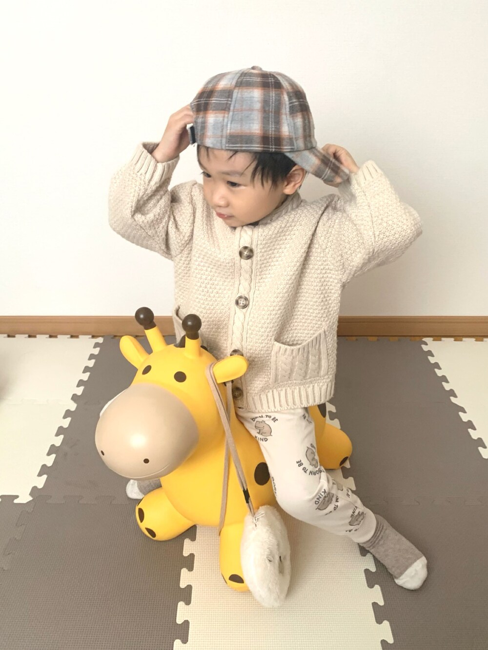 ベージュ系のニット/セーター、ホワイト系のスウェットパンツ、ベージュ系のキャップを着用したキッズの冬コーディネートの2枚目の写真