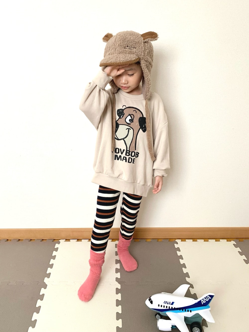 ホワイト系のスウェット、ブルー系のその他パンツ、ブラウン系の帽子を着用したキッズの冬コーディネートの2枚目の写真