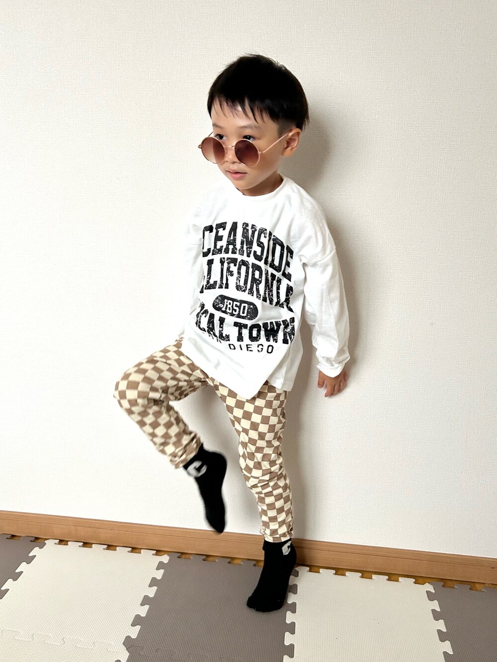 ブラウン系のその他パンツ、ホワイト系のTシャツ/カットソー、ブラウン系のサングラスを着用したキッズの秋コーディネートの3枚目の写真