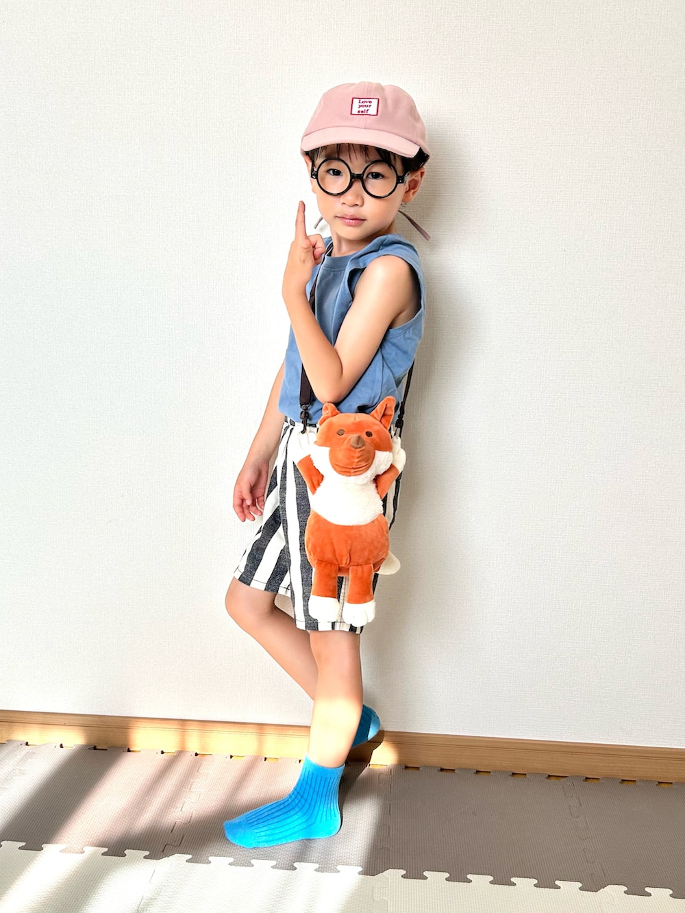 ブルー系のタンクトップ、ホワイト系のパンツ、ブラウン系のショルダーバッグを着用したキッズの夏コーディネートの3枚目の写真