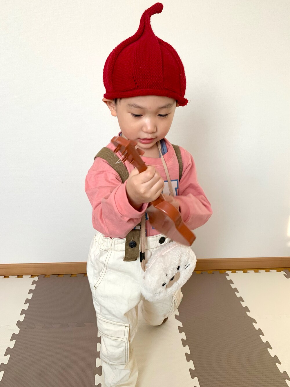 ピンク系のTシャツ/カットソー、ホワイト系のサロペット/オーバーオール、ベージュ系のカーディガン/ボレロを着用したキッズの冬コーディネートの5枚目の写真