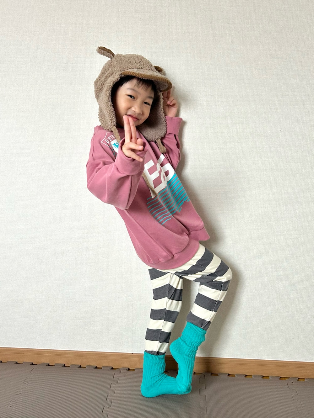 ピンク系のスウェット、グレー系のその他パンツ、グリーン系のソックス/靴下を着用したキッズの秋コーディネートの2枚目の写真