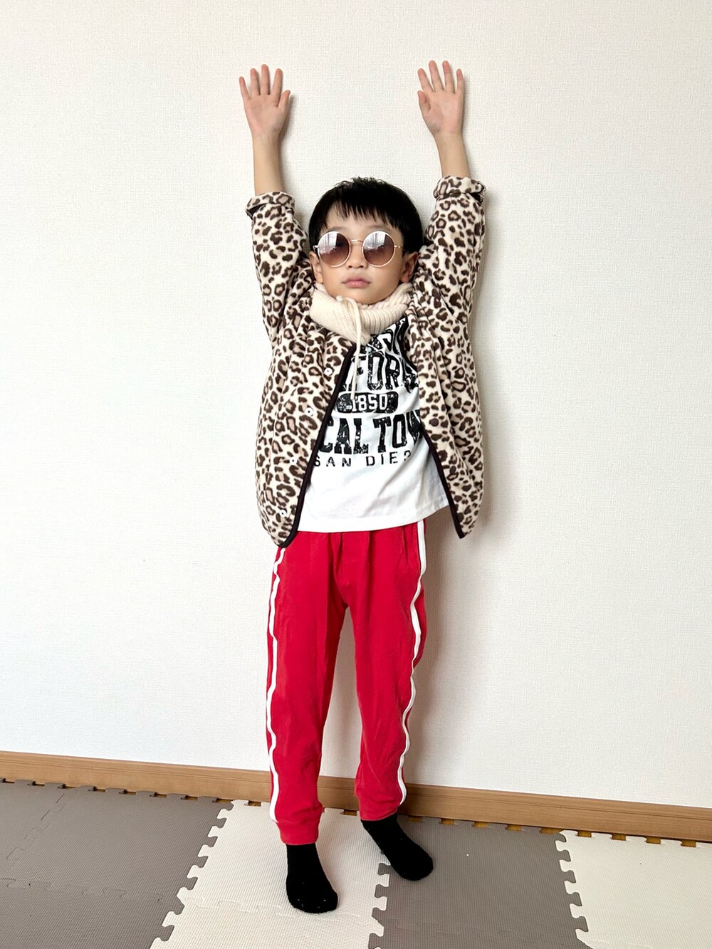 レッド系のスウェットパンツ、ベージュ系のカーディガン/ボレロ、ホワイト系のTシャツ/カットソーを着用したキッズの秋コーディネートの5枚目の写真