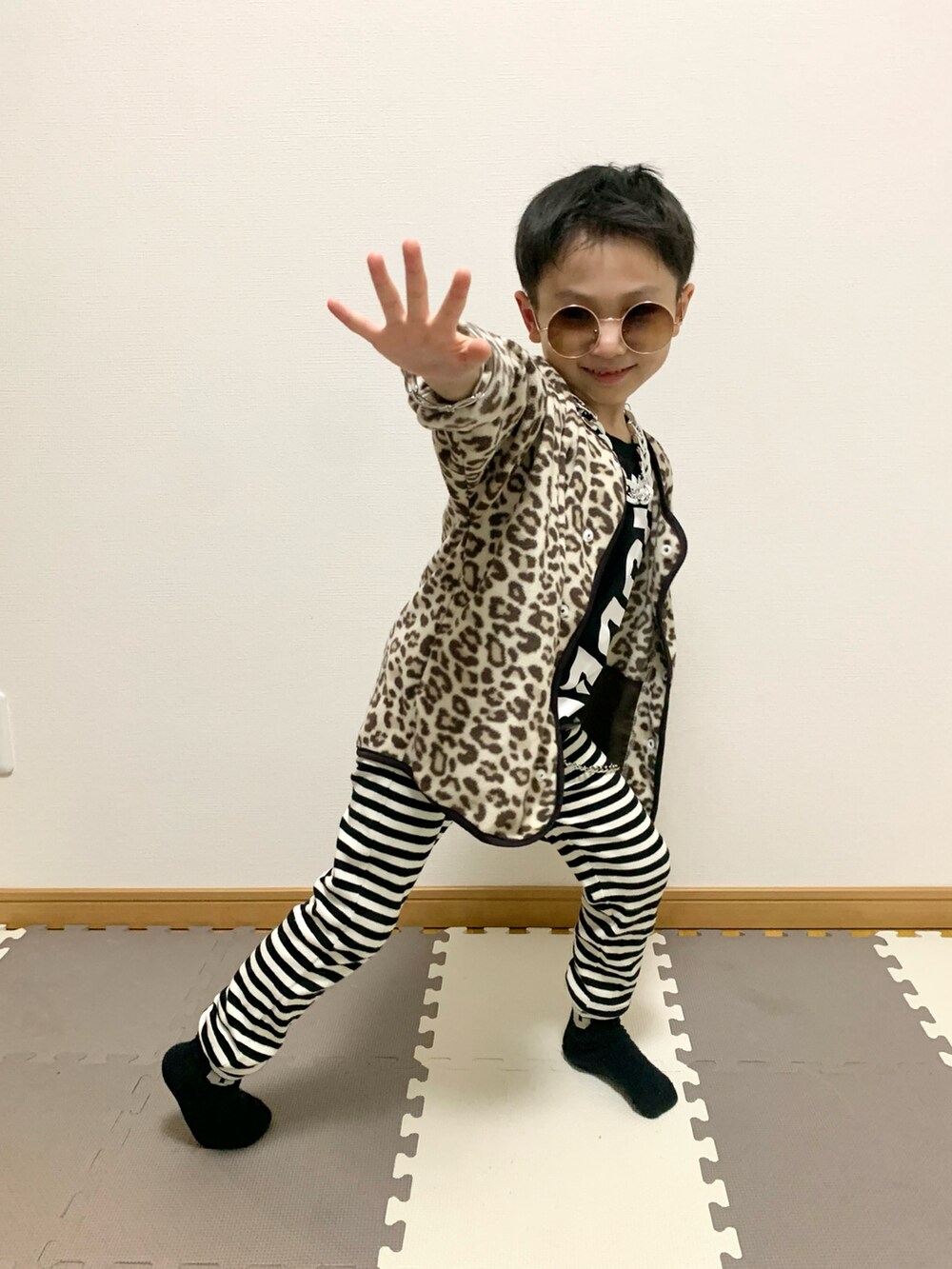 ベージュ系のカーディガン/ボレロ、ホワイト系のパンツ、ブラック系のTシャツ/カットソーを着用したキッズの冬コーディネートの5枚目の写真