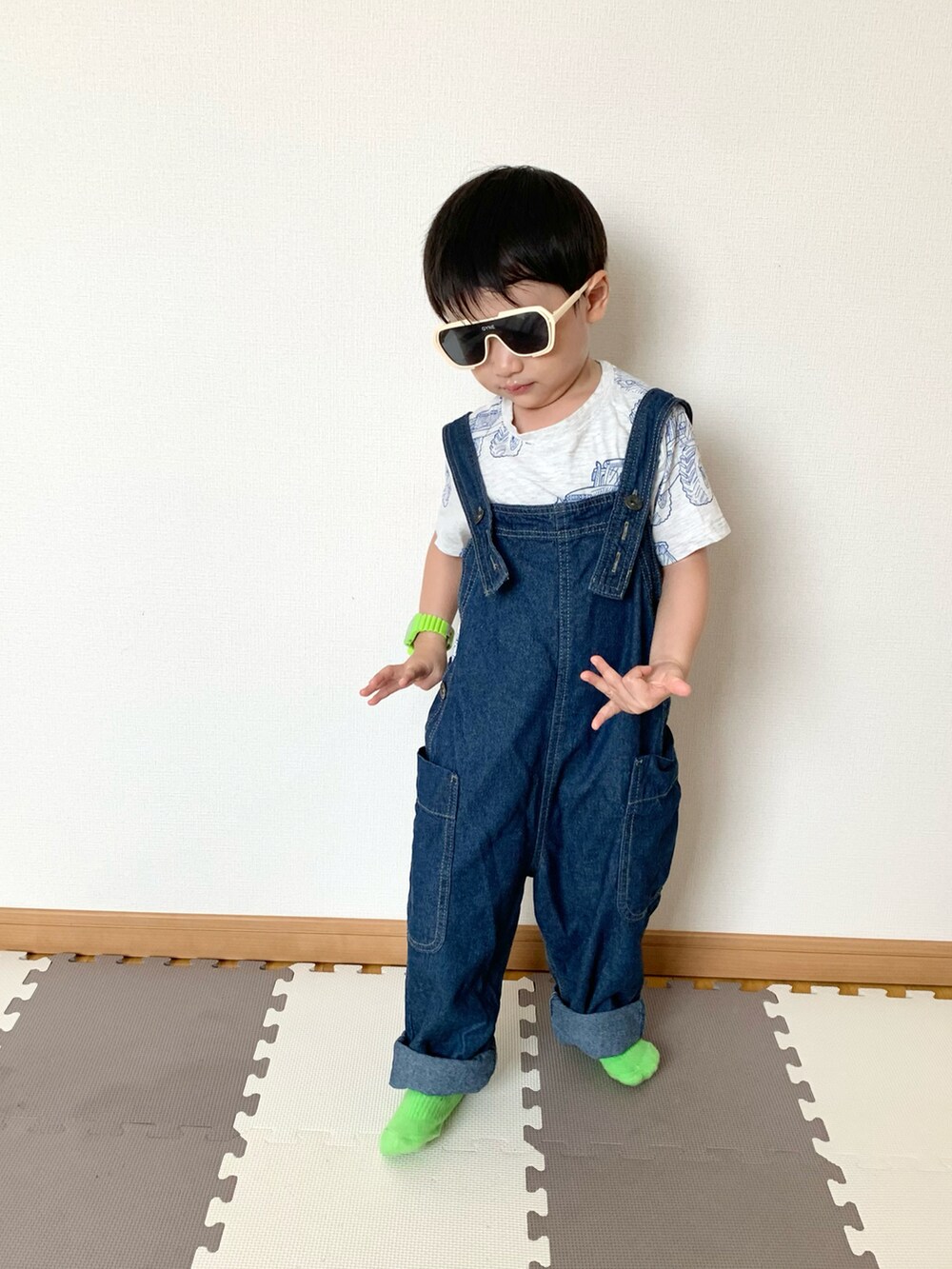 ブルー系のサロペット/オーバーオール、グレー系のTシャツ/カットソー、ホワイト系のサングラスを着用したキッズの春コーディネートの4枚目の写真