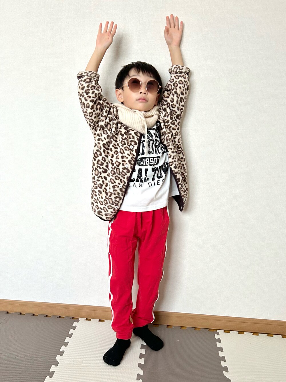 レッド系のスウェットパンツ、ベージュ系のカーディガン/ボレロ、ホワイト系のTシャツ/カットソーを着用したキッズの秋コーディネートの4枚目の写真