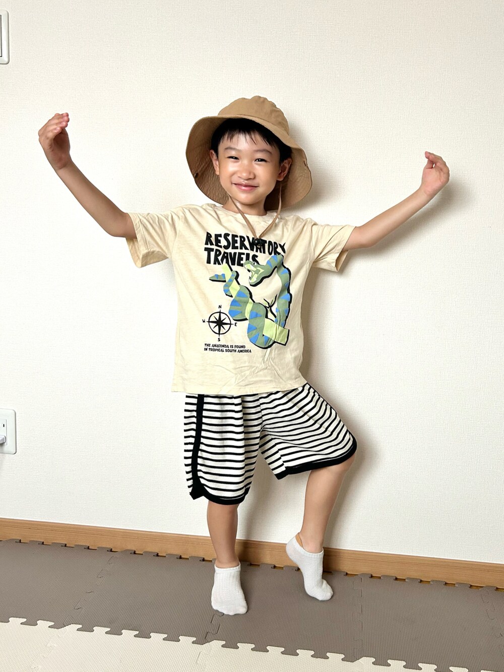 ホワイト系のセットアップ、ベージュ系のTシャツ/カットソー、オレンジ系のソックス/靴下を着用したキッズの夏コーディネートの3枚目の写真