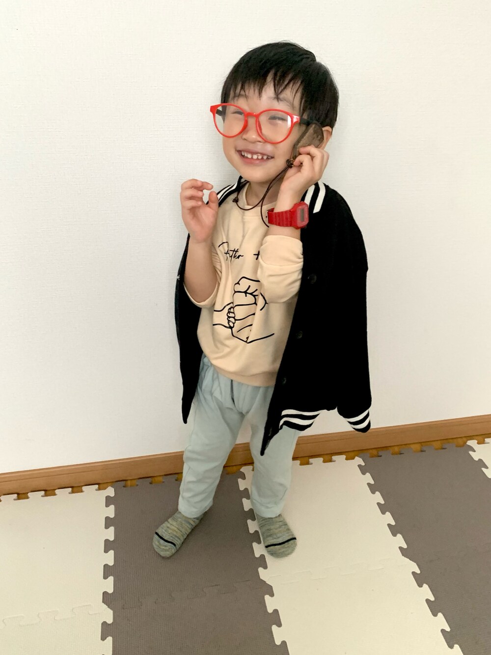 グリーン系のスウェットパンツ、ブラック系のブルゾン、ベージュ系のスウェットを着用したキッズの冬コーディネートの3枚目の写真