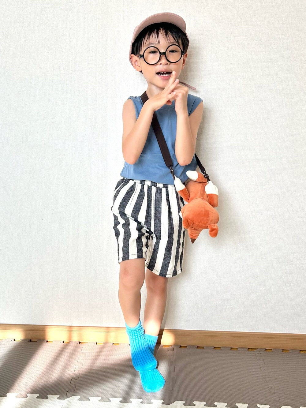 ブルー系のタンクトップ、ホワイト系のパンツ、ブラウン系のショルダーバッグを着用したキッズの夏コーディネートの2枚目の写真