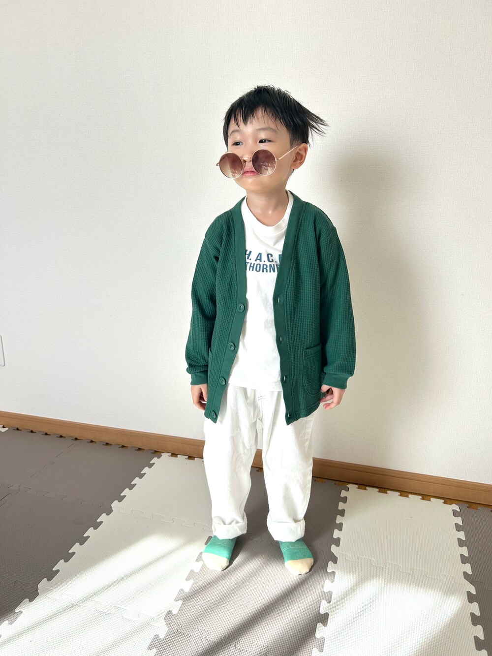 ホワイト系のデニムパンツ、ホワイト系のTシャツ/カットソー、グリーン系のカーディガン/ボレロを着用したキッズの春コーディネートの4枚目の写真