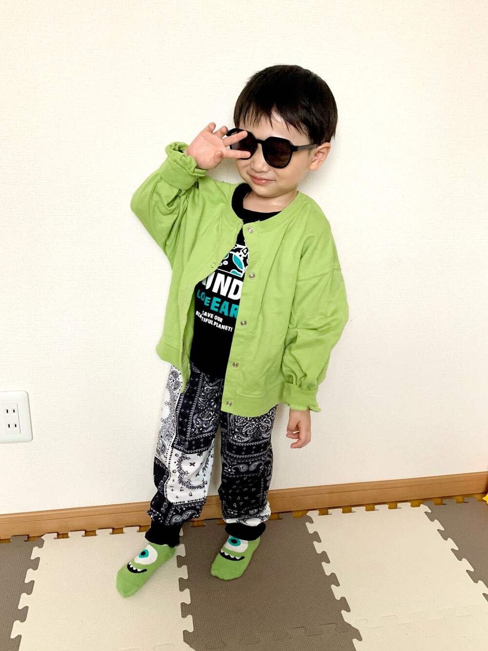 グリーン系のカーディガン/ボレロ、ブラック系のTシャツ/カットソー、ブルー系のスウェットパンツを着用したキッズの春コーディネートの2枚目の写真
