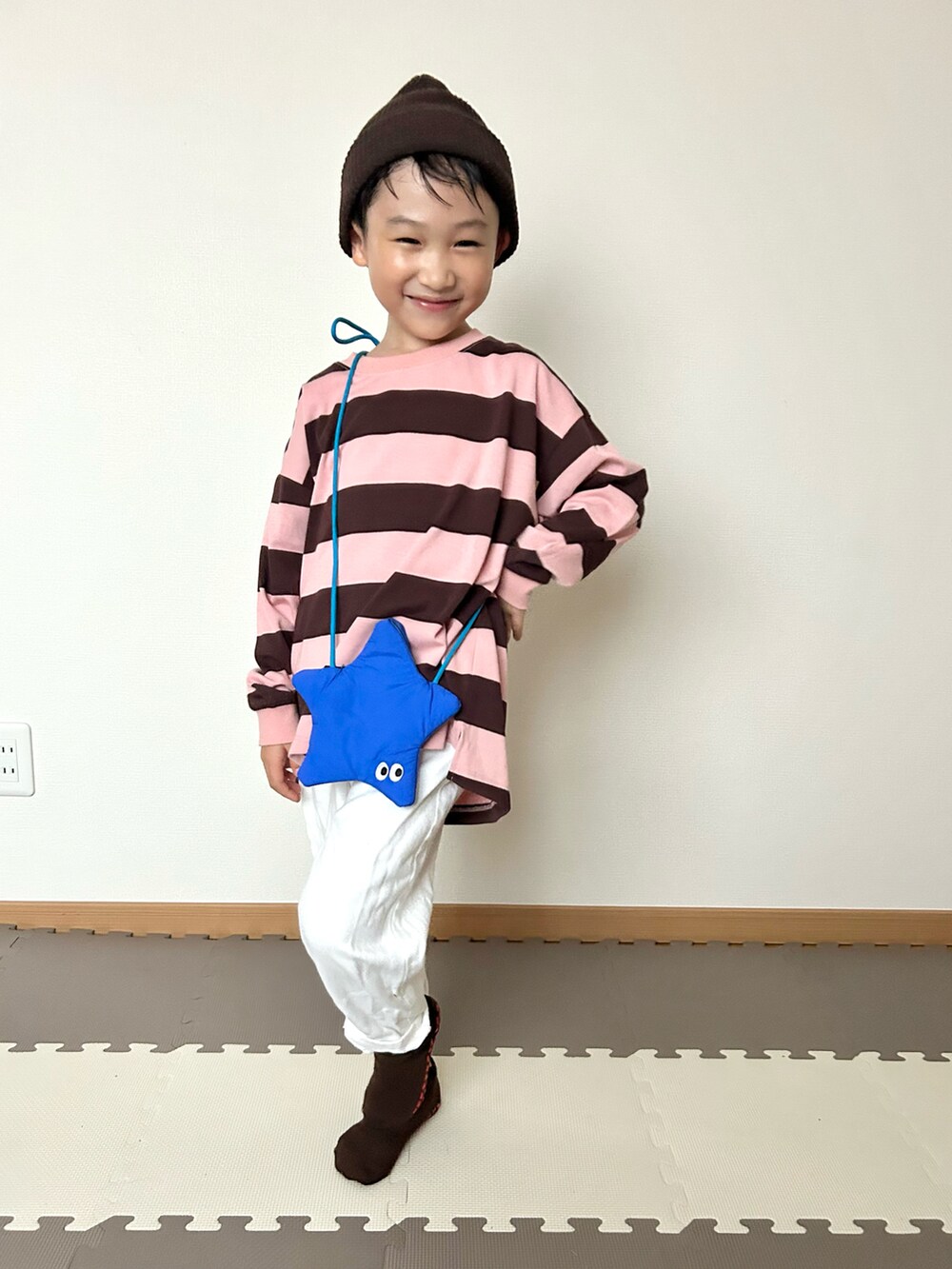 ピンク系のTシャツ/カットソー、ホワイト系のデニムパンツ、ブルー系のショルダーバッグを着用したキッズの秋コーディネートの5枚目の写真