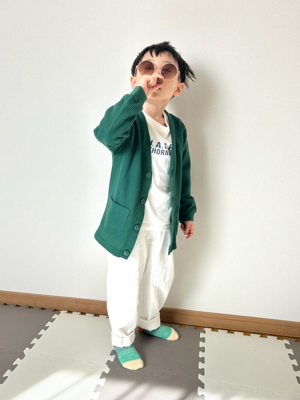 ホワイト系のデニムパンツ、ホワイト系のTシャツ/カットソー、グリーン系のカーディガン/ボレロを着用したキッズの春コーディネートの5枚目の写真