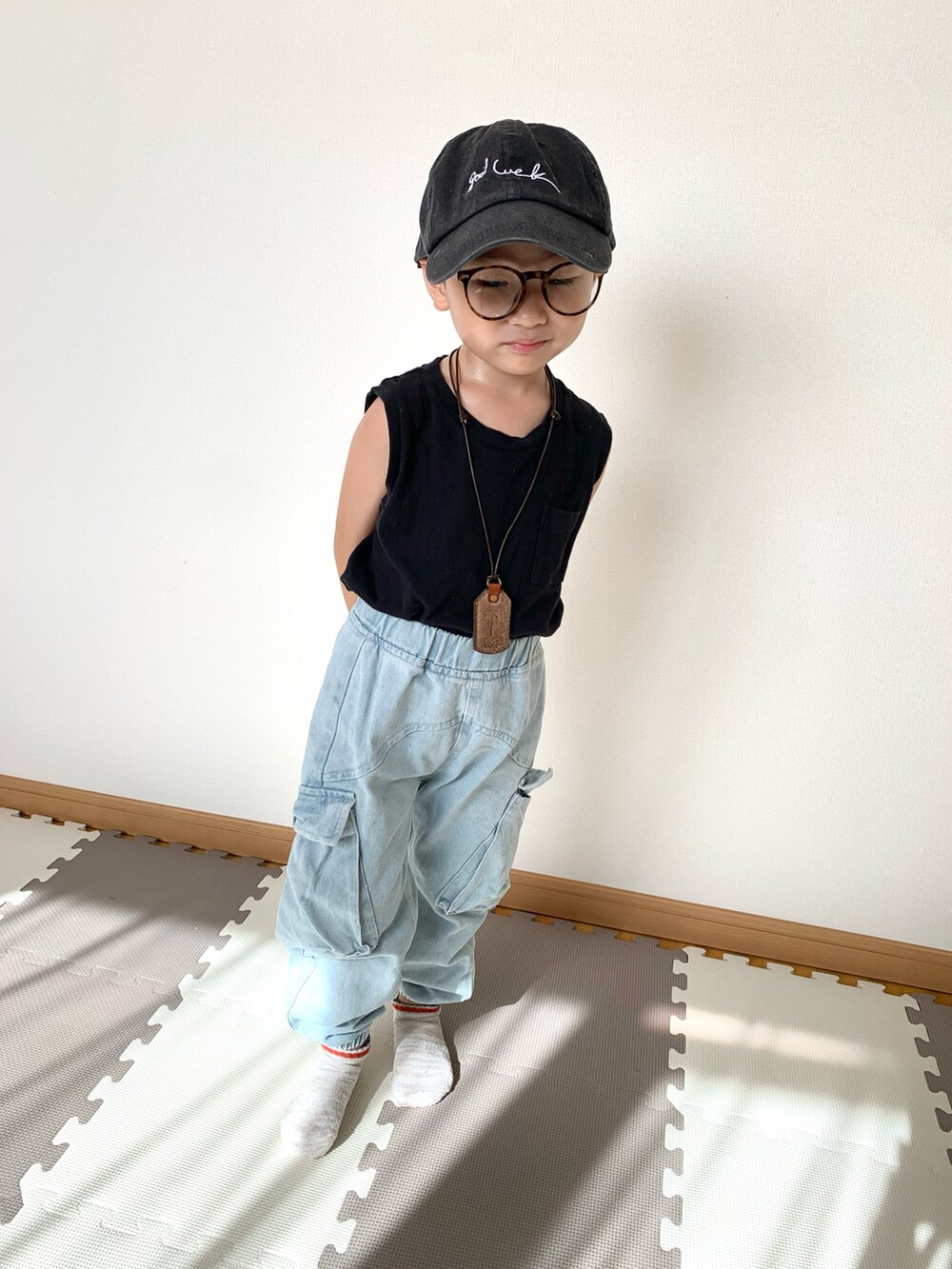 ブルー系のデニムパンツ、ブラック系のタンクトップ、ブラック系のキャップを着用したキッズの夏コーディネートの4枚目の写真