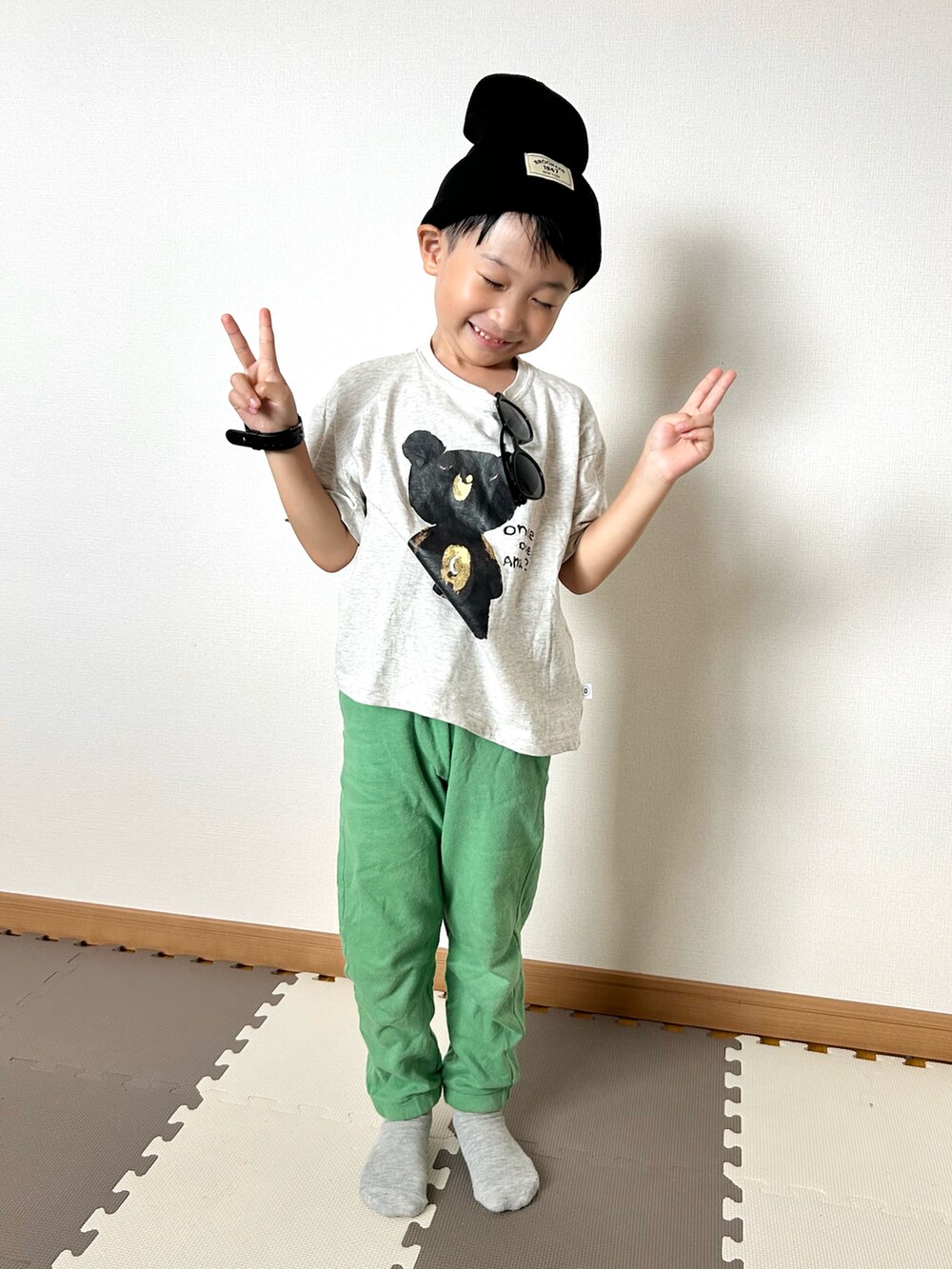 グリーン系のスウェットパンツ、グレー系のTシャツ/カットソー、ブラック系のサングラスを着用したキッズの秋コーディネートの3枚目の写真