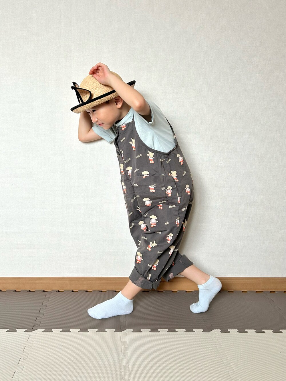 グレー系のサロペット/オーバーオール、グリーン系のTシャツ/カットソー、ベージュ系のハットを着用したキッズの夏コーディネートの5枚目の写真