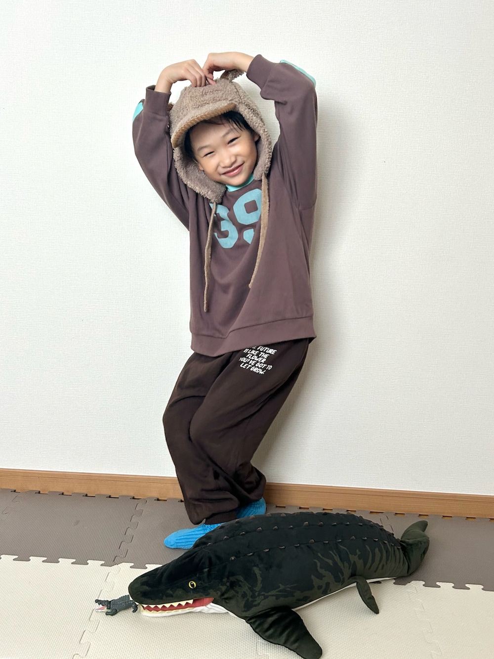 ブラウン系のスウェット、ブラウン系のスウェットパンツ、ブラウン系の帽子を着用したキッズの冬コーディネートの2枚目の写真