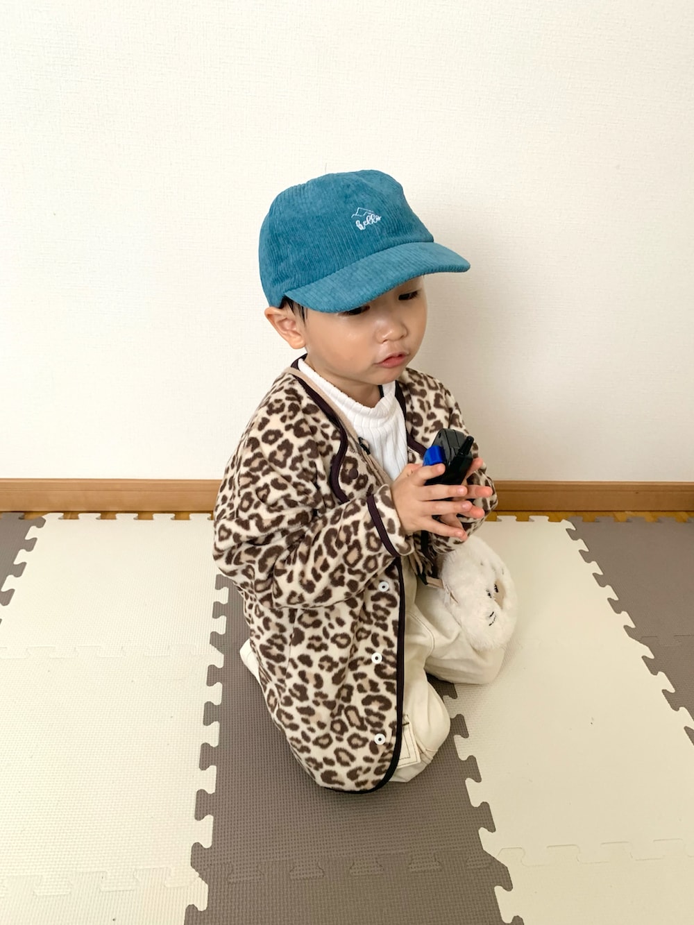 ベージュ系のカーディガン/ボレロ、ホワイト系のTシャツ/カットソー、ホワイト系のサロペット/オーバーオールを着用したキッズの冬コーディネートの3枚目の写真