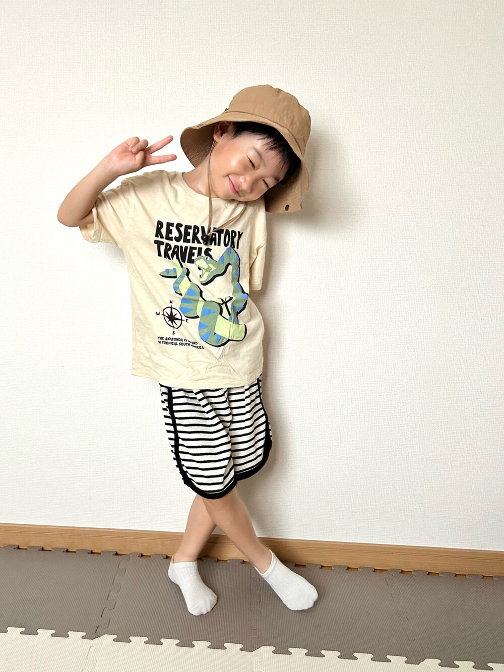 ホワイト系のセットアップ、ベージュ系のTシャツ/カットソー、オレンジ系のソックス/靴下を着用したキッズの夏コーディネートの2枚目の写真