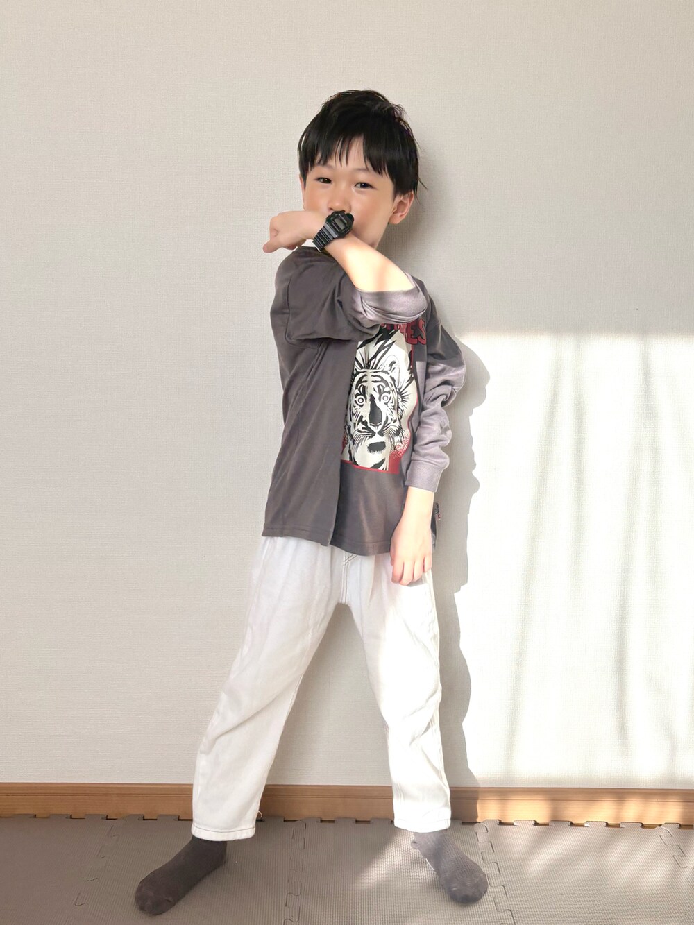 グレー系のTシャツ/カットソー、ホワイト系のデニムパンツ、ブラック系の腕時計を着用したキッズの春コーディネートの2枚目の写真