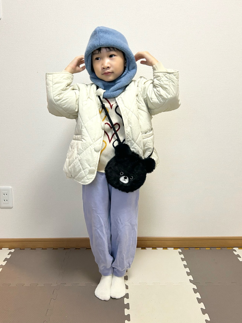 パープル系のスウェットパンツ、ホワイト系のブルゾン、その他のニット/セーターを着用したキッズの冬コーディネートの3枚目の写真