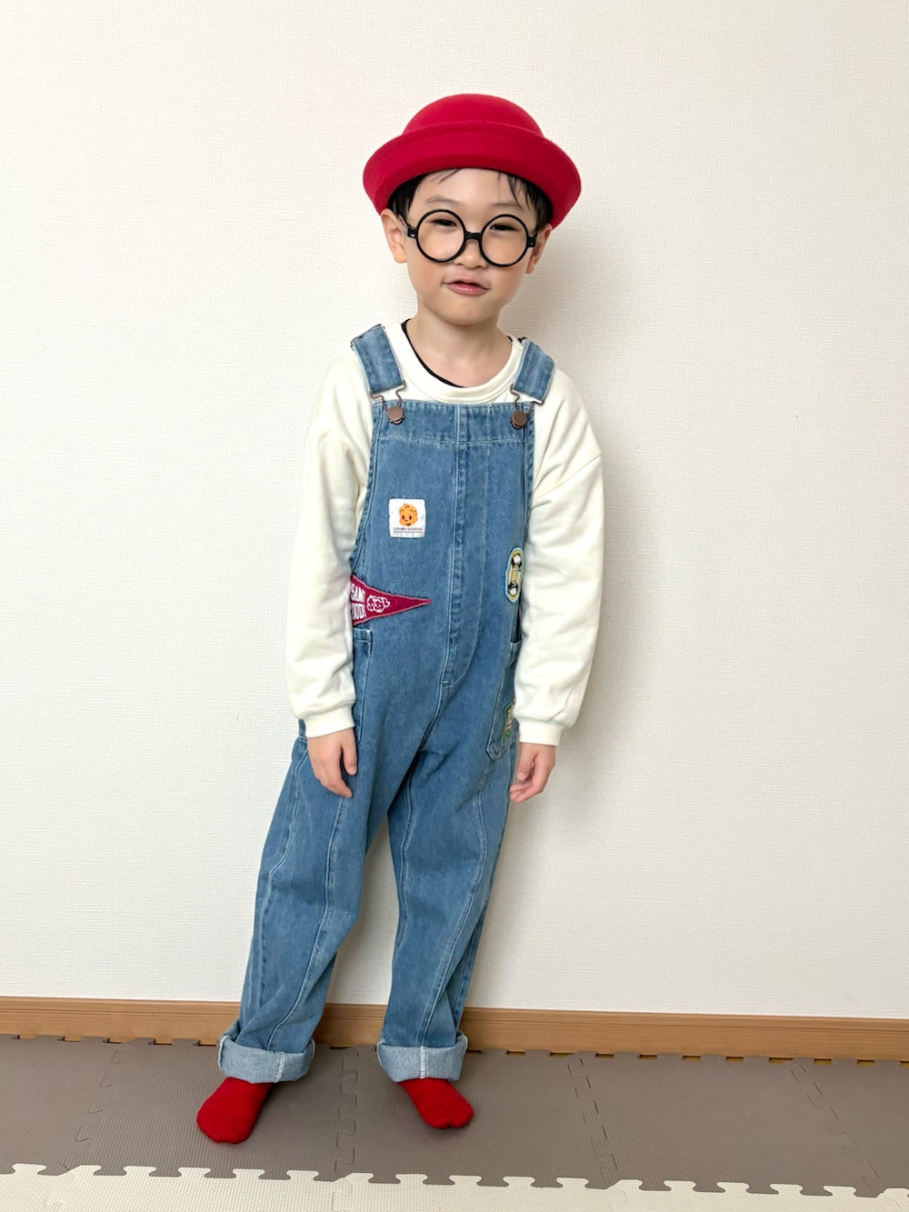 ブルー系のサロペット/オーバーオール、レッド系のハット、ホワイト系のその他を着用したキッズの春コーディネートの3枚目の写真