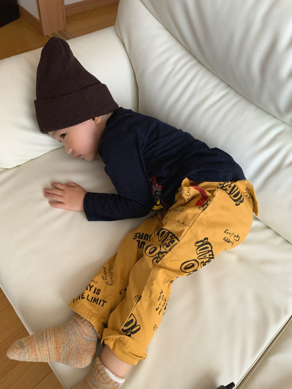 ブルー系のTシャツ/カットソー、イエロー系のチノパンツ、ブラウン系のニットキャップ/ビーニーを着用したキッズの秋コーディネートの3枚目の写真