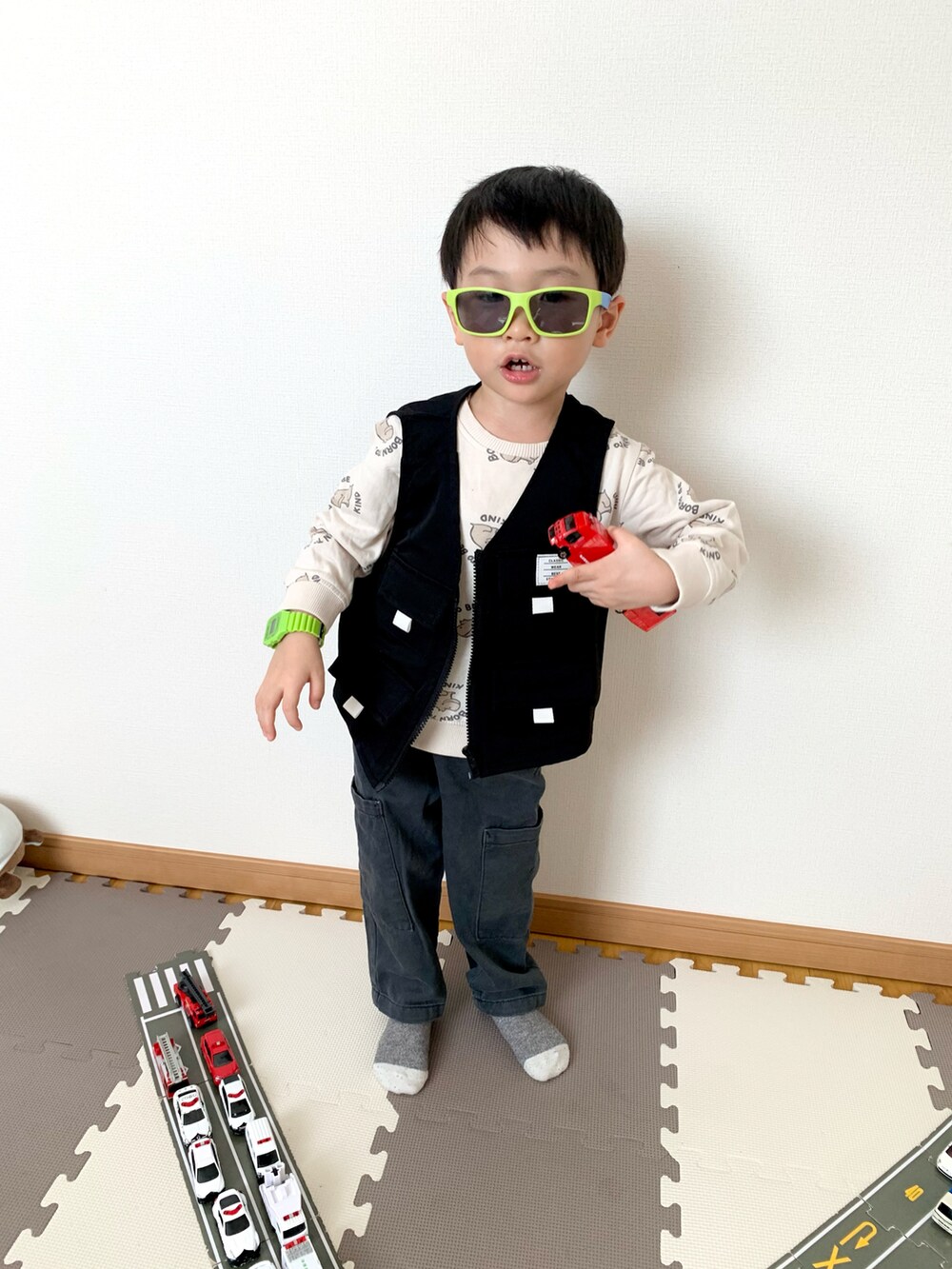 グレー系のカーゴパンツ、ブラック系のベスト、ホワイト系のスウェットを着用したキッズの春コーディネートの3枚目の写真