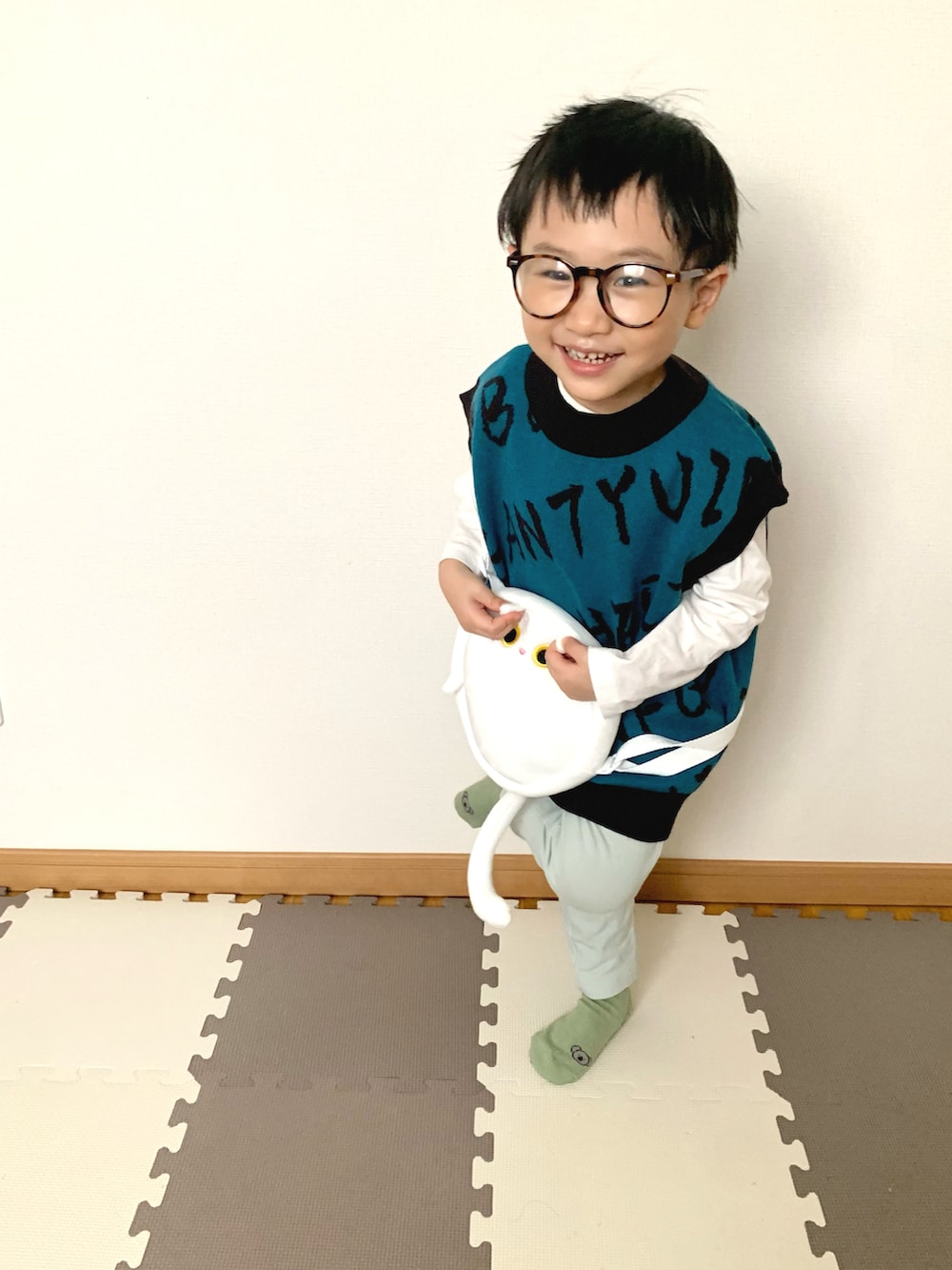 ブルー系のベスト、ホワイト系のTシャツ/カットソー、グリーン系のスウェットパンツを着用したキッズの春コーディネートの2枚目の写真