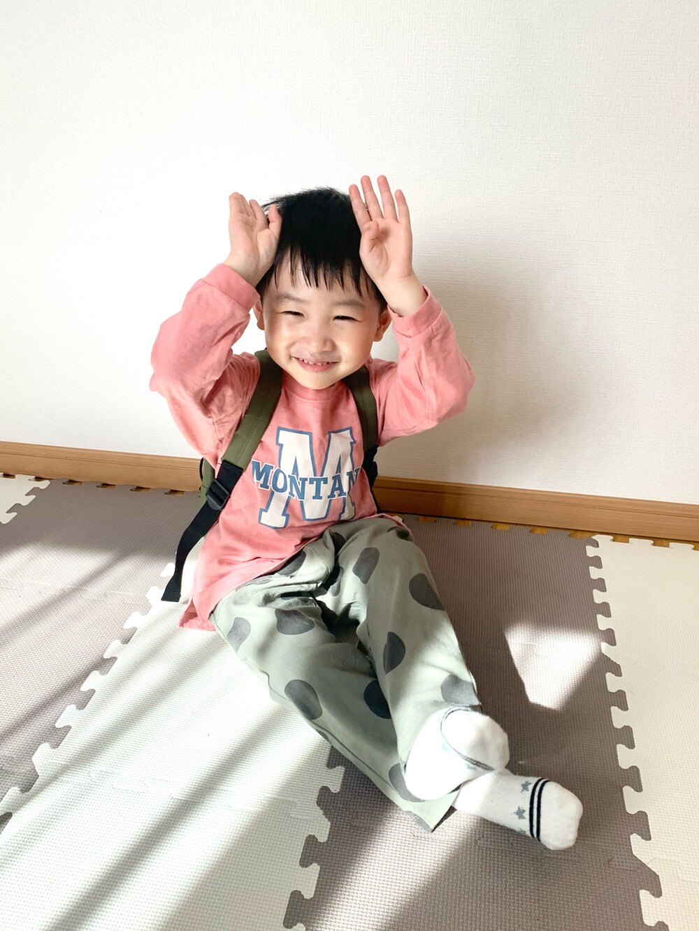 ピンク系のTシャツ/カットソー、グリーン系のその他パンツ、グリーン系のバックパック/リュックを着用したキッズの春コーディネートの2枚目の写真