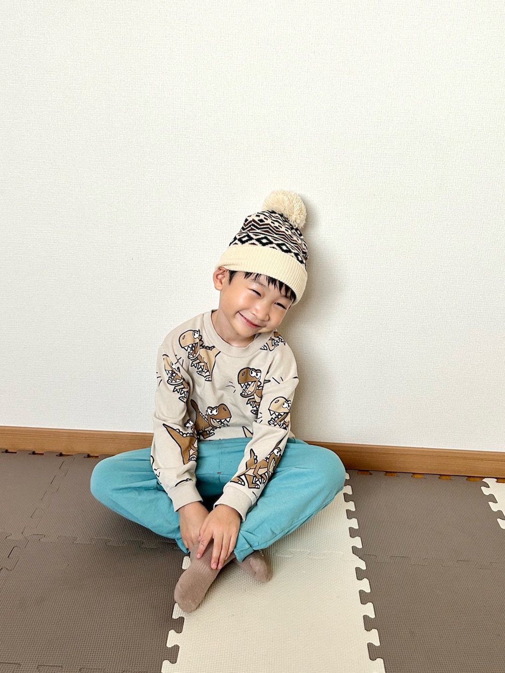 ベージュ系のスウェット、ブルー系のその他パンツ、ホワイト系のニットキャップ/ビーニーを着用したキッズの秋コーディネートの2枚目の写真