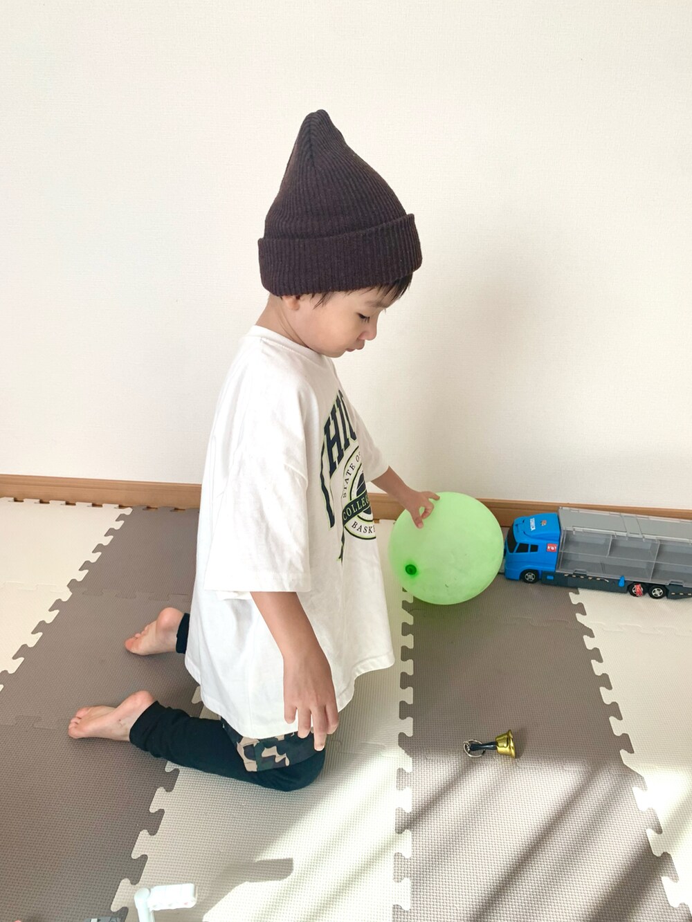 ホワイト系のTシャツ/カットソー、グリーン系のパンツ、ブラウン系のニットキャップ/ビーニーを着用したキッズの秋コーディネートの3枚目の写真