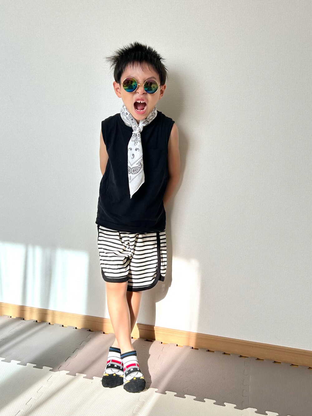 ホワイト系のセットアップ、ブラック系のタンクトップ、ホワイト系のソックス/靴下を着用したキッズの夏コーディネートの3枚目の写真