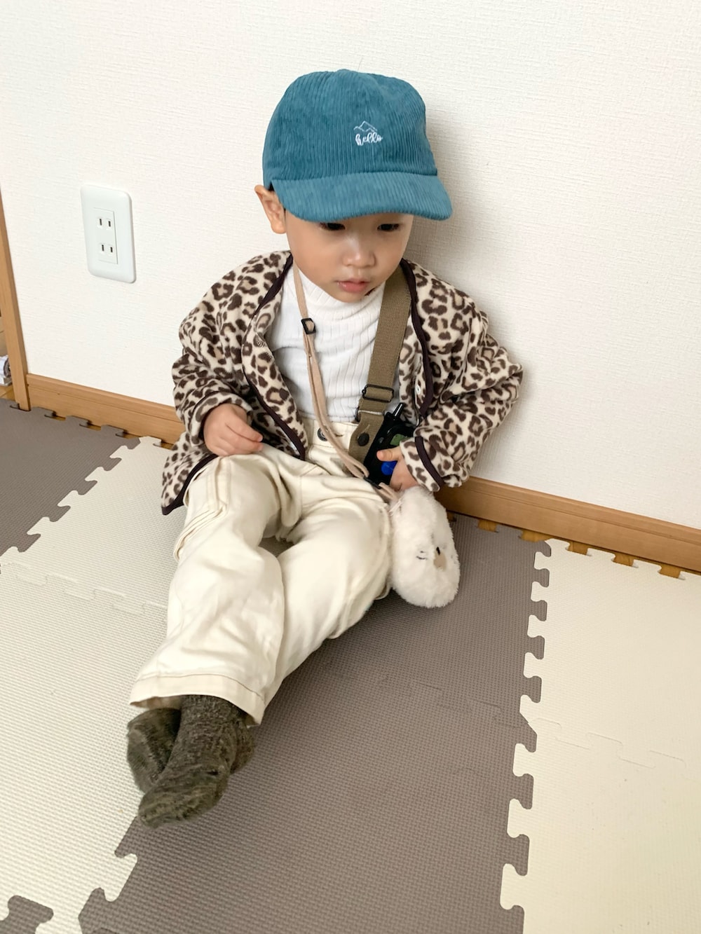 ベージュ系のカーディガン/ボレロ、ホワイト系のTシャツ/カットソー、ホワイト系のサロペット/オーバーオールを着用したキッズの冬コーディネートの4枚目の写真