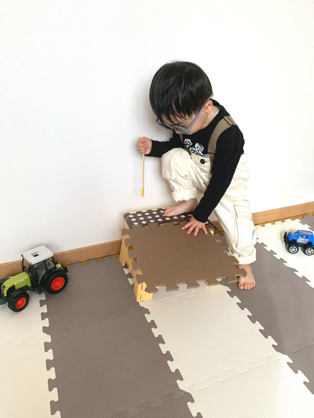 ホワイト系のサロペット/オーバーオール、ブラック系のTシャツ/カットソー、パープル系のサングラスを着用したキッズの秋コーディネートの2枚目の写真