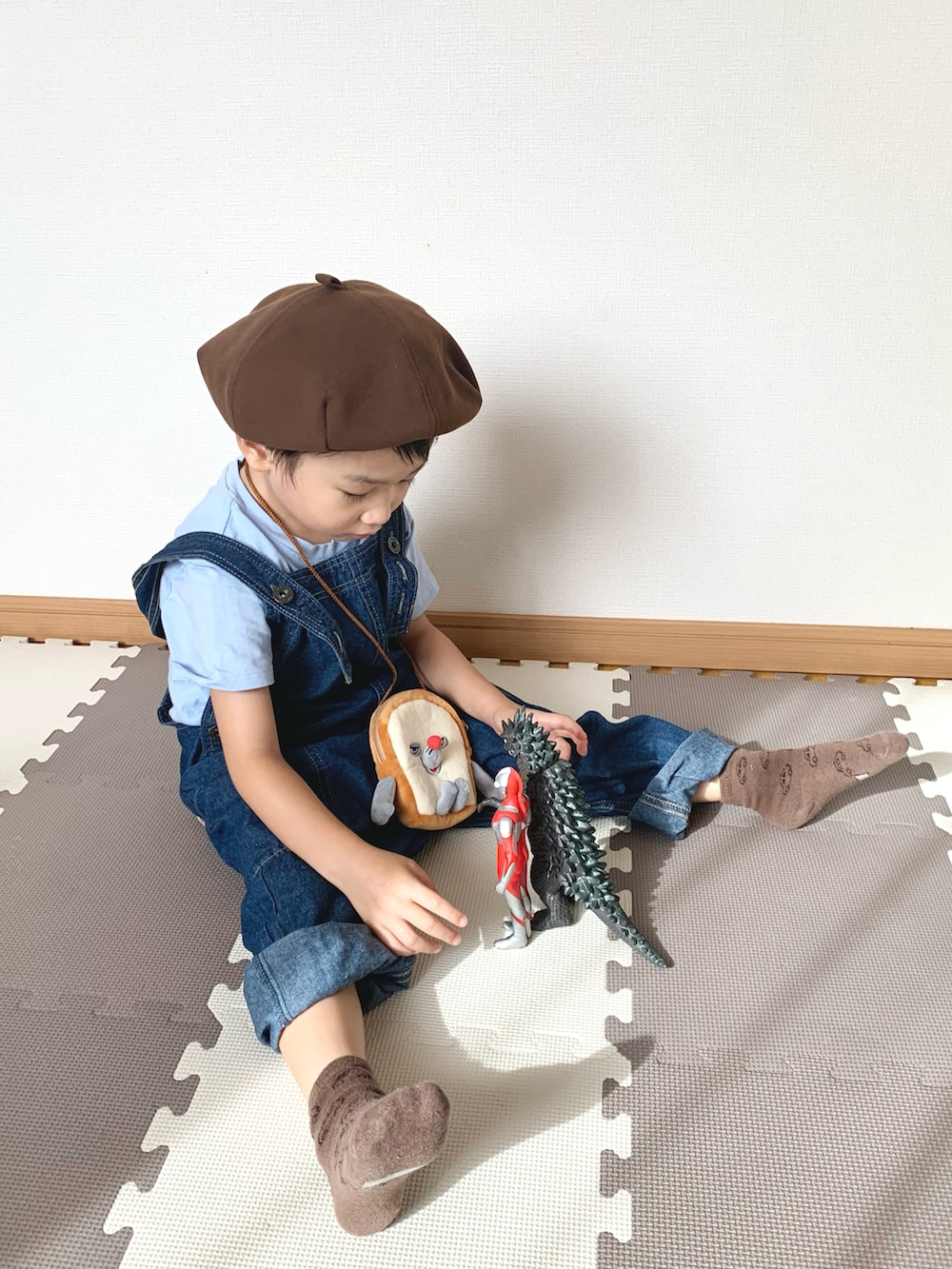 ブルー系のサロペット/オーバーオール、ブラウン系のショルダーバッグ、ブルー系のTシャツ/カットソーを着用したキッズの秋コーディネートの5枚目の写真